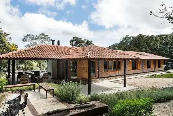 Fachadas de casas térreas com telhado aparente: tijolinhos e madeira compõem fachada rústica (projeto: RAP Arquitetura e Interiores)