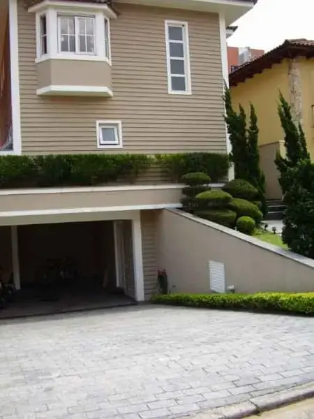 Garagem subterrânea em casa com janela bay window (foto: Vai Com Tudo)