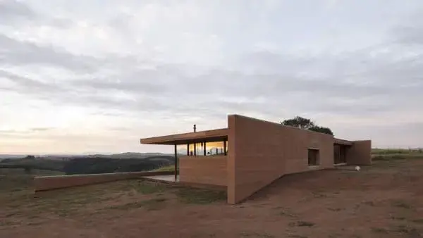 Taipa de pilão moderna casa com janela em fita se integra ao ambiente foto Casa em Cunha Arquipélago Arquitetos. Foto Federico Cairoli