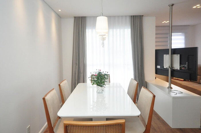 Sala de jantar com mesa laqueada e cadeiras de madeira. Fonte: Condecorar Arquitetura e Interiores